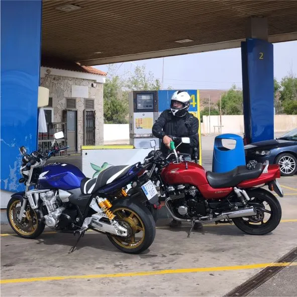 Two Honda CB750 and CB1300 motorcycles refuelling during a motorcycle tour on the road up to Tetir in Fuerteventura.