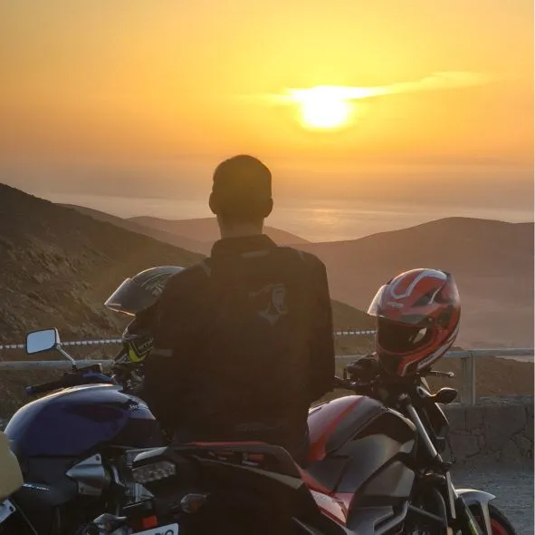 Tourist enjoying a sunset in El Cotillo during a full-day motorcycle tour in Fuerteventura.