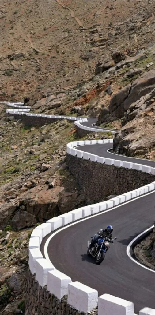 Motorcycle riding through beautiful winding curves on the mountain road near Betancuria during a scenic tour in Fuerteventura.