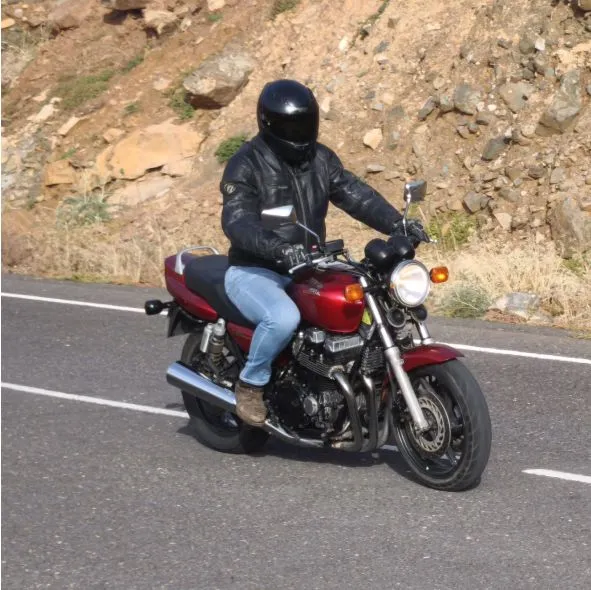 Tourist enjoying riding a Honda CB750 during a motorcycle tour on an open road in Fuerteventura.